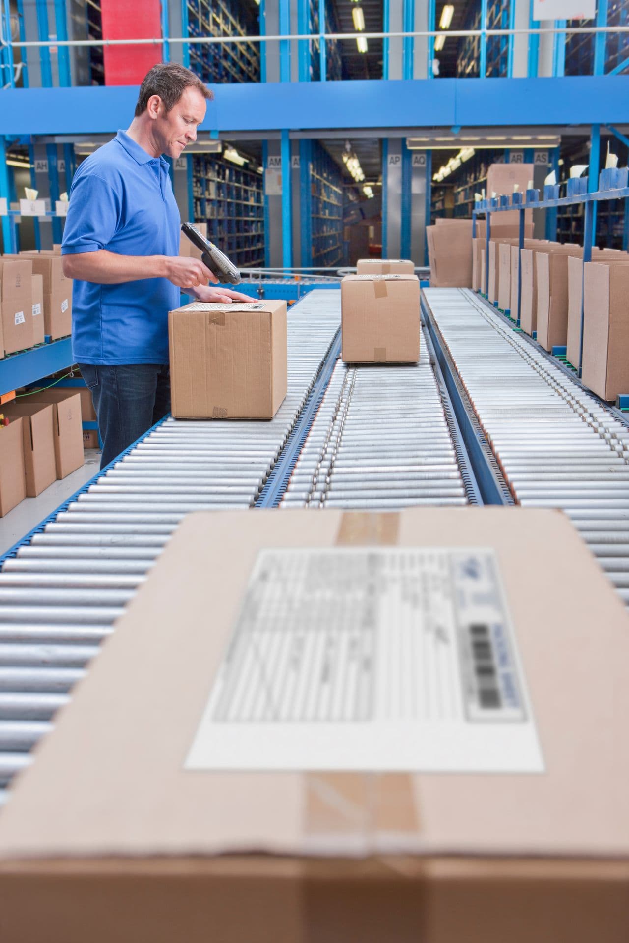 Operator scanning cartons on a conveyor line
