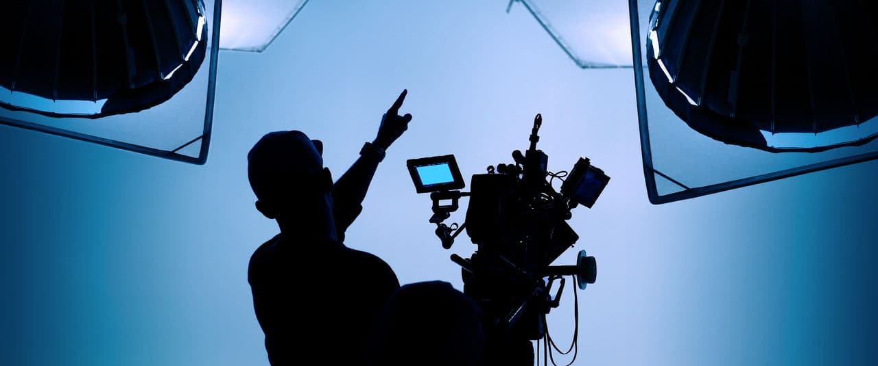 Crew member operating a camera rig on a set