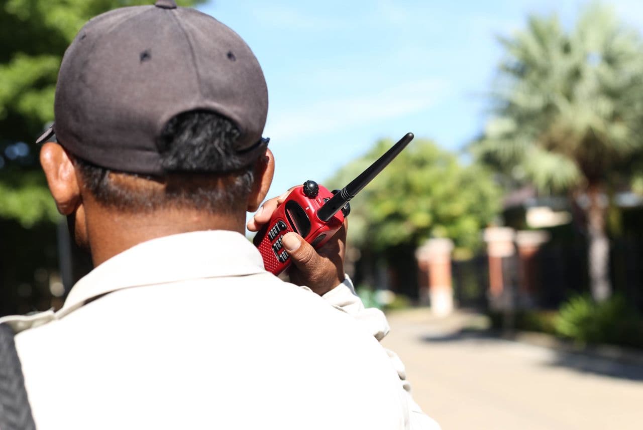 Field officer using a handheld radio on a residential street