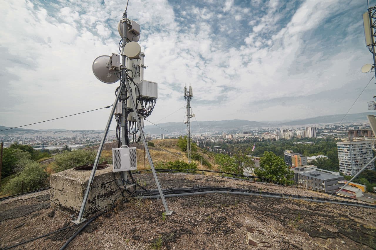 Telecommunications tower above a city skyline