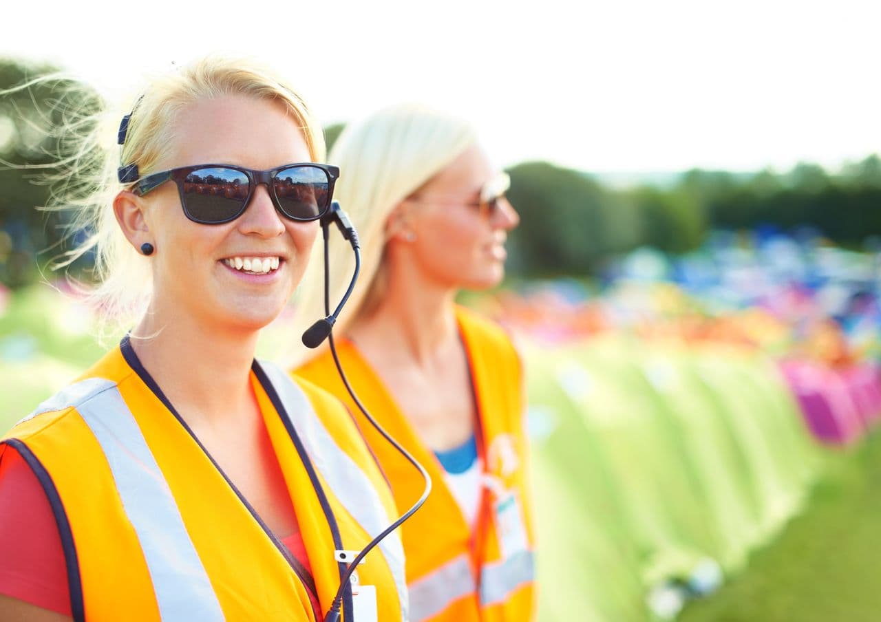 Event staff in high-visibility vests wearing headsets